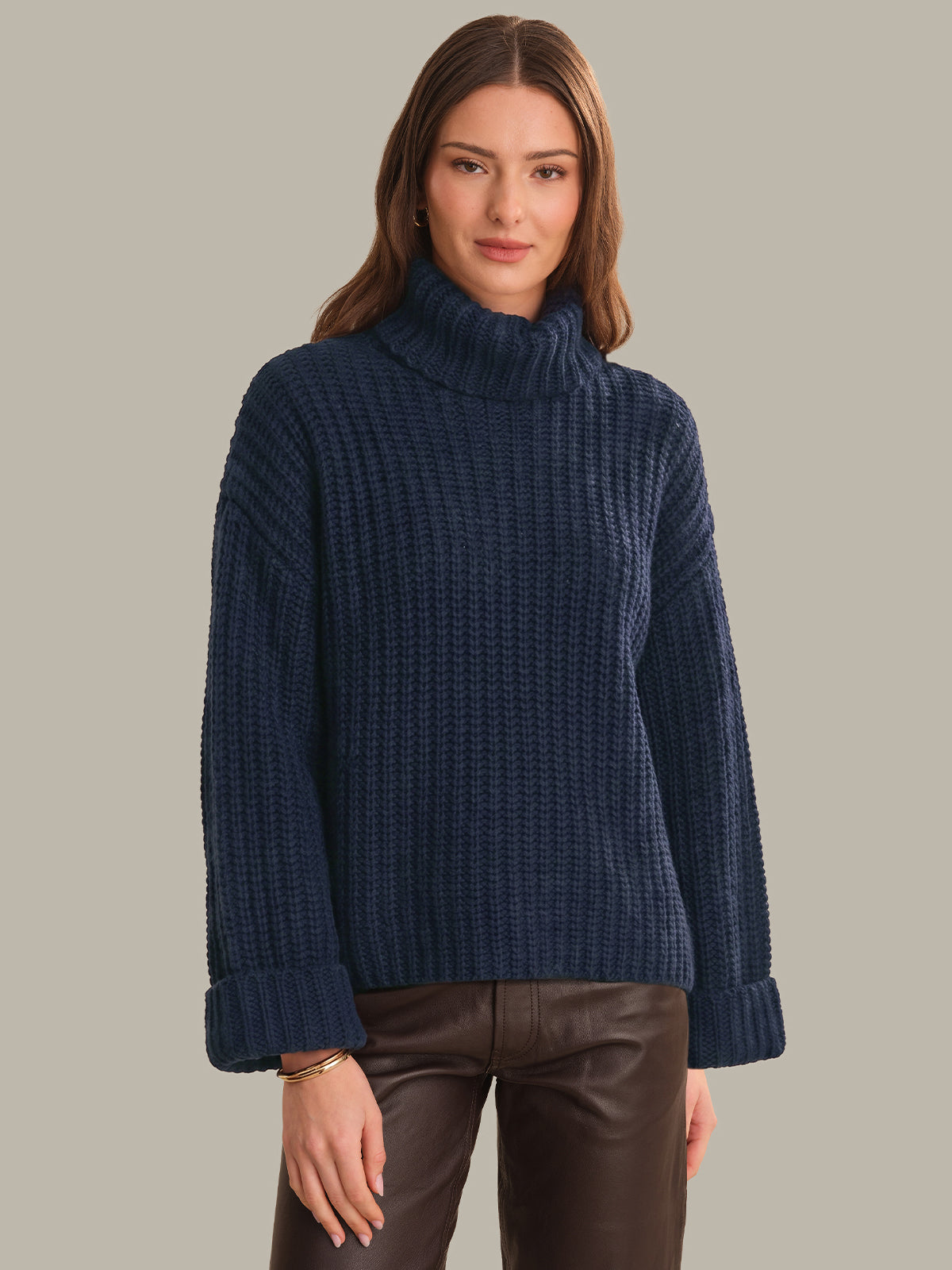 Woman wearing a blue turtleneck sweater against a neutral background