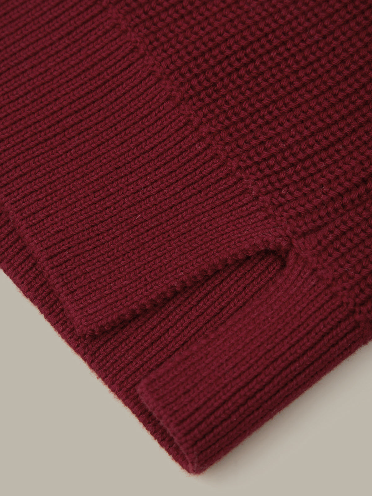 Close-up of a burgundy knitted fabric on a beige background