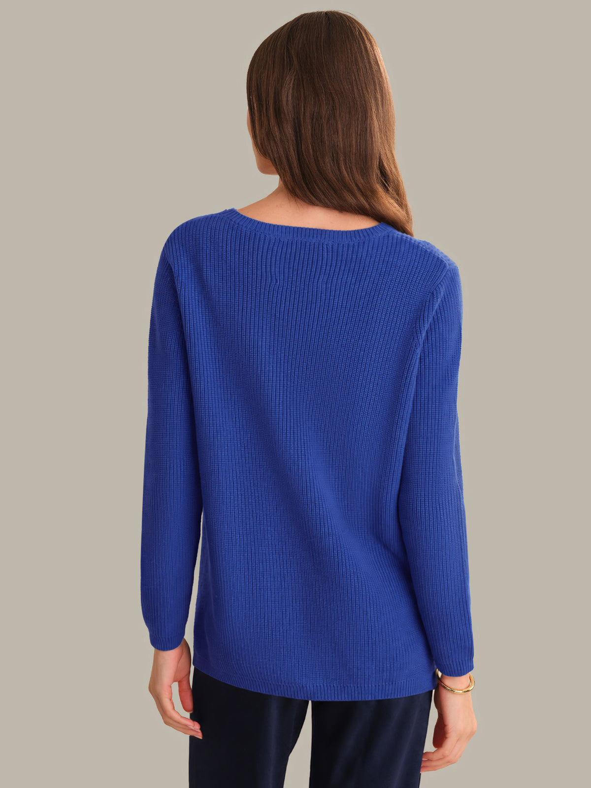 Woman wearing a blue sweater on a plain background