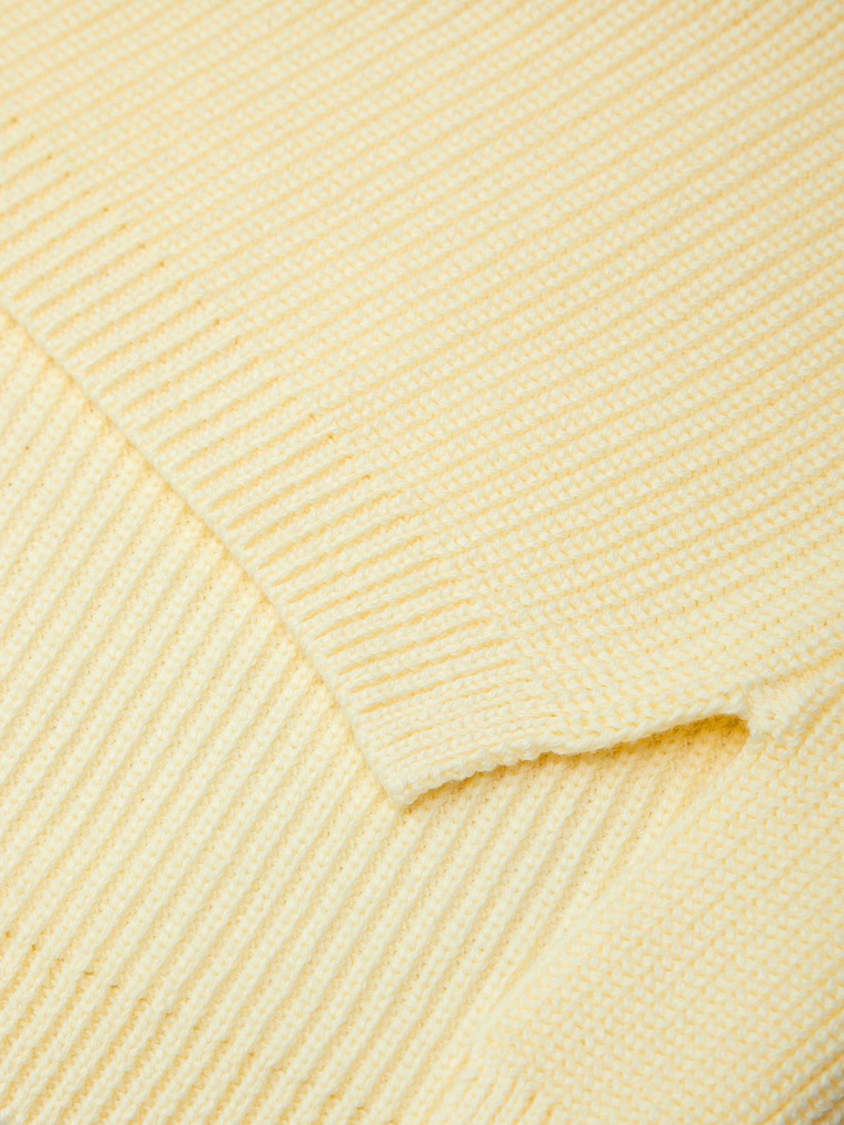 Close-up of a textured yellow fabric with a diamond pattern