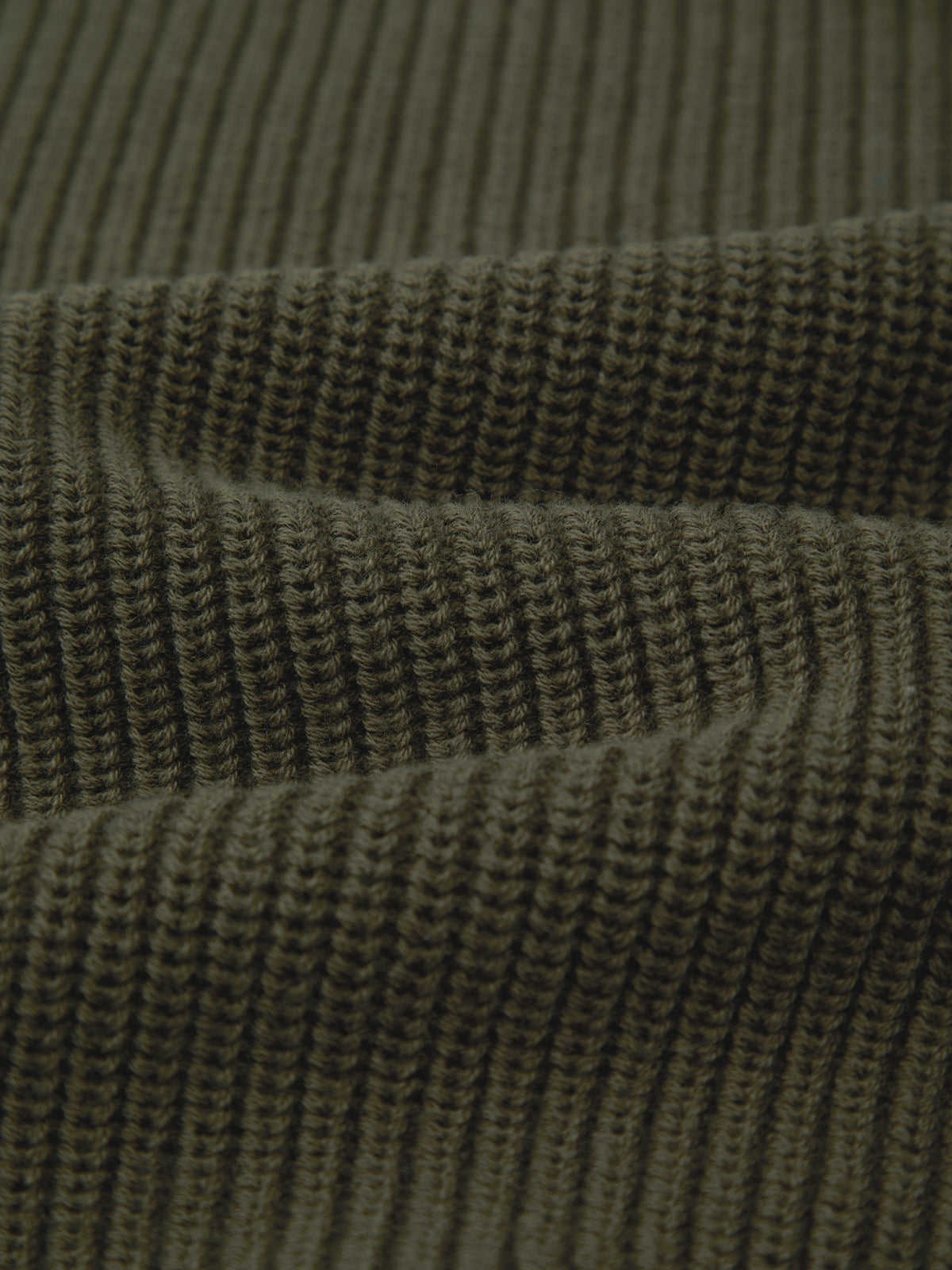 Close-up view of a dark olive green ribbed fabric by 525 America, showcasing the detailed horizontal ridges and pattern of the versatile shaker stitch.