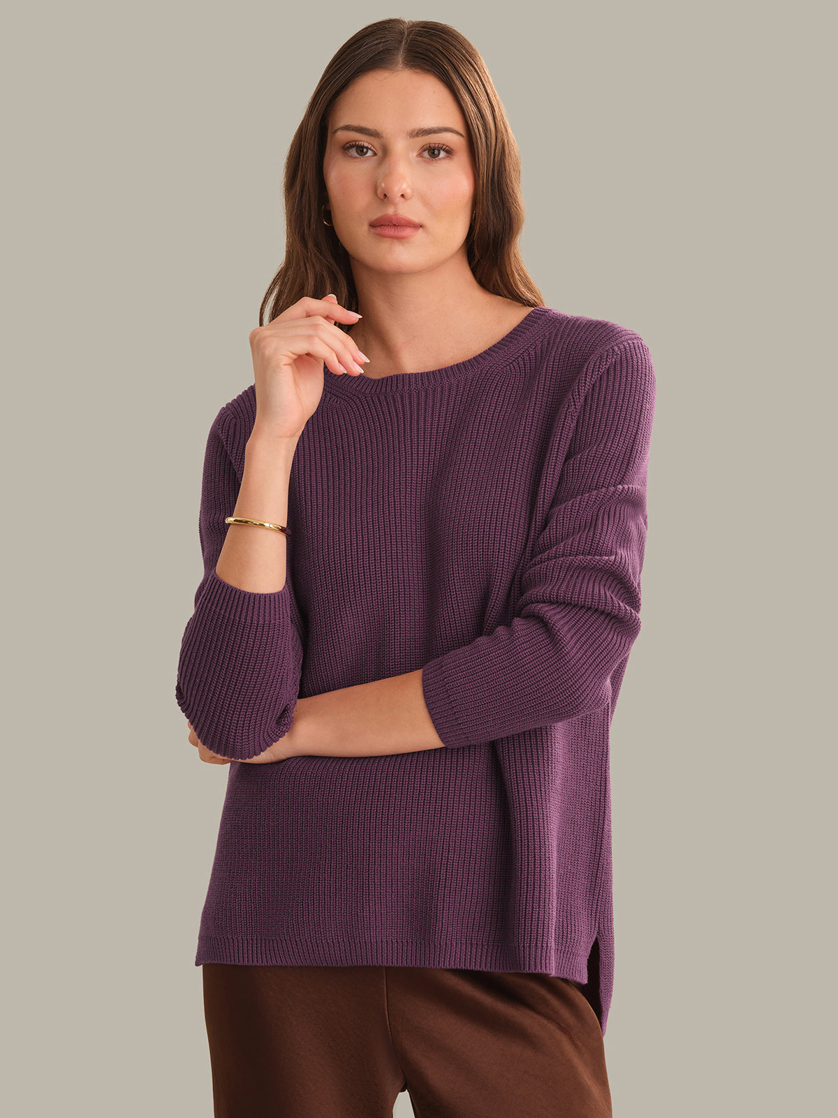 Woman wearing a purple sweater against a plain background
