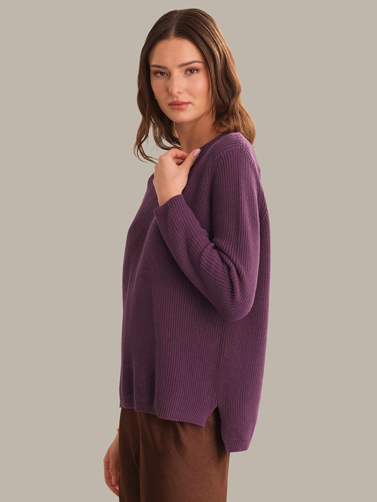 Woman wearing a purple sweater against a plain background