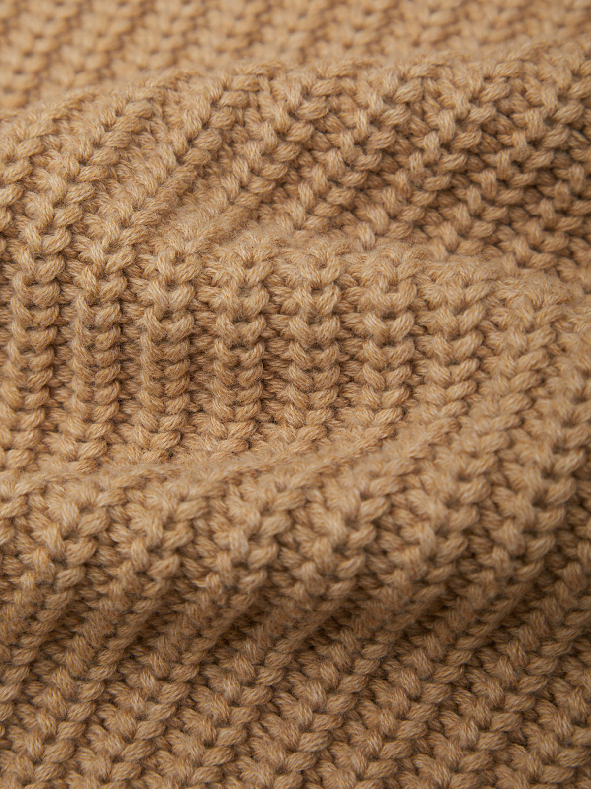 Close-up of a beige knitted fabric texture