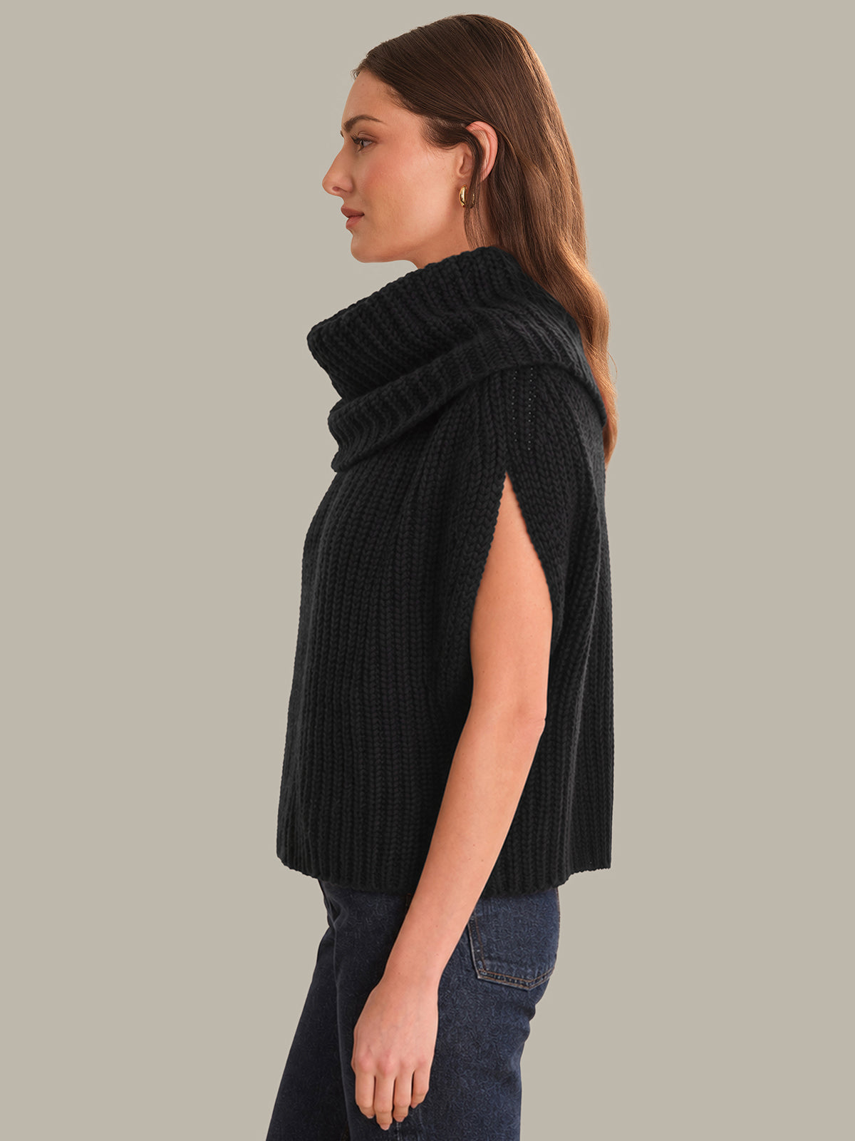 Woman wearing a black ribbed knit vest against a plain background