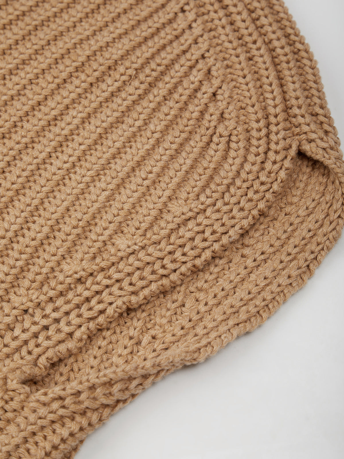 Close-up of a beige knitted fabric on a white background