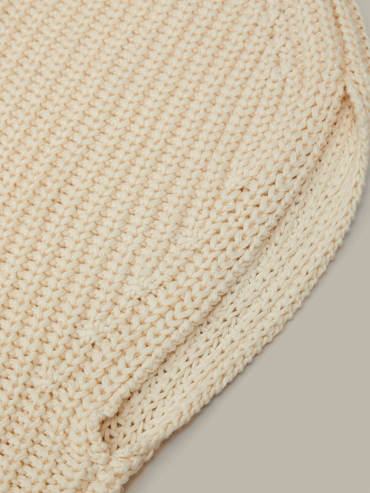 Close-up of a beige woven mat on a neutral background
