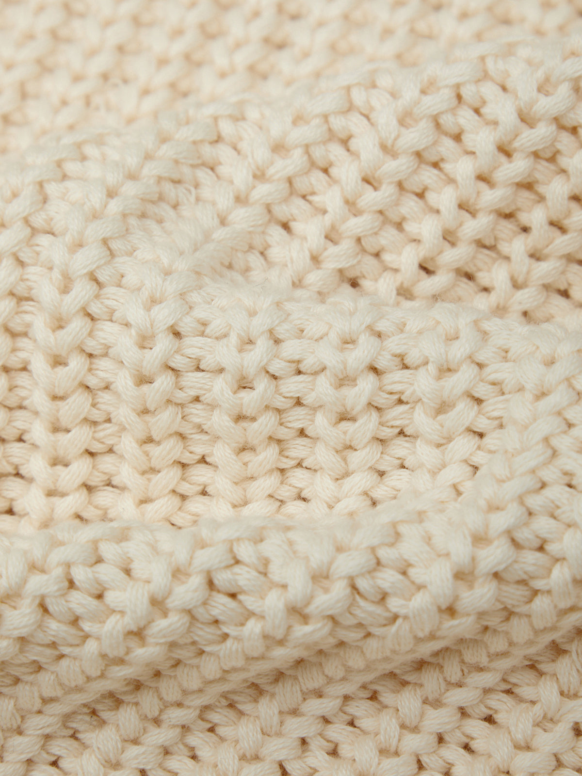 Close-up of beige knitted fabric texture