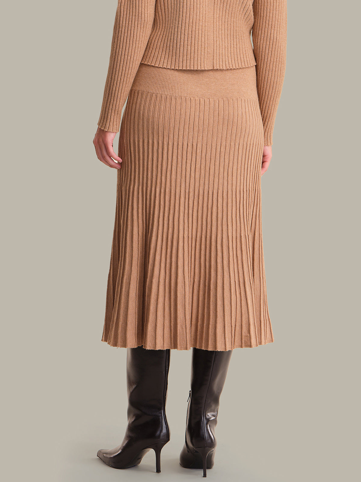 Person wearing a brown ribbed knit skirt and sweater set on a plain background