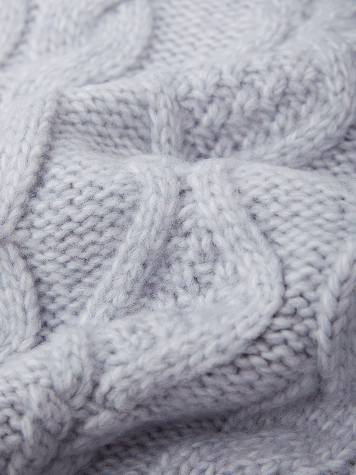 Close-up of a textured blue fabric with cable knit pattern