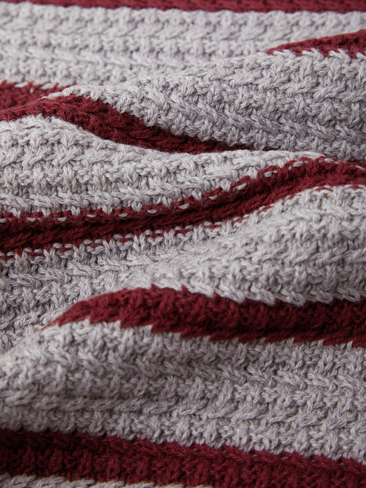 Close-up of a textured fabric with red and gray stripes