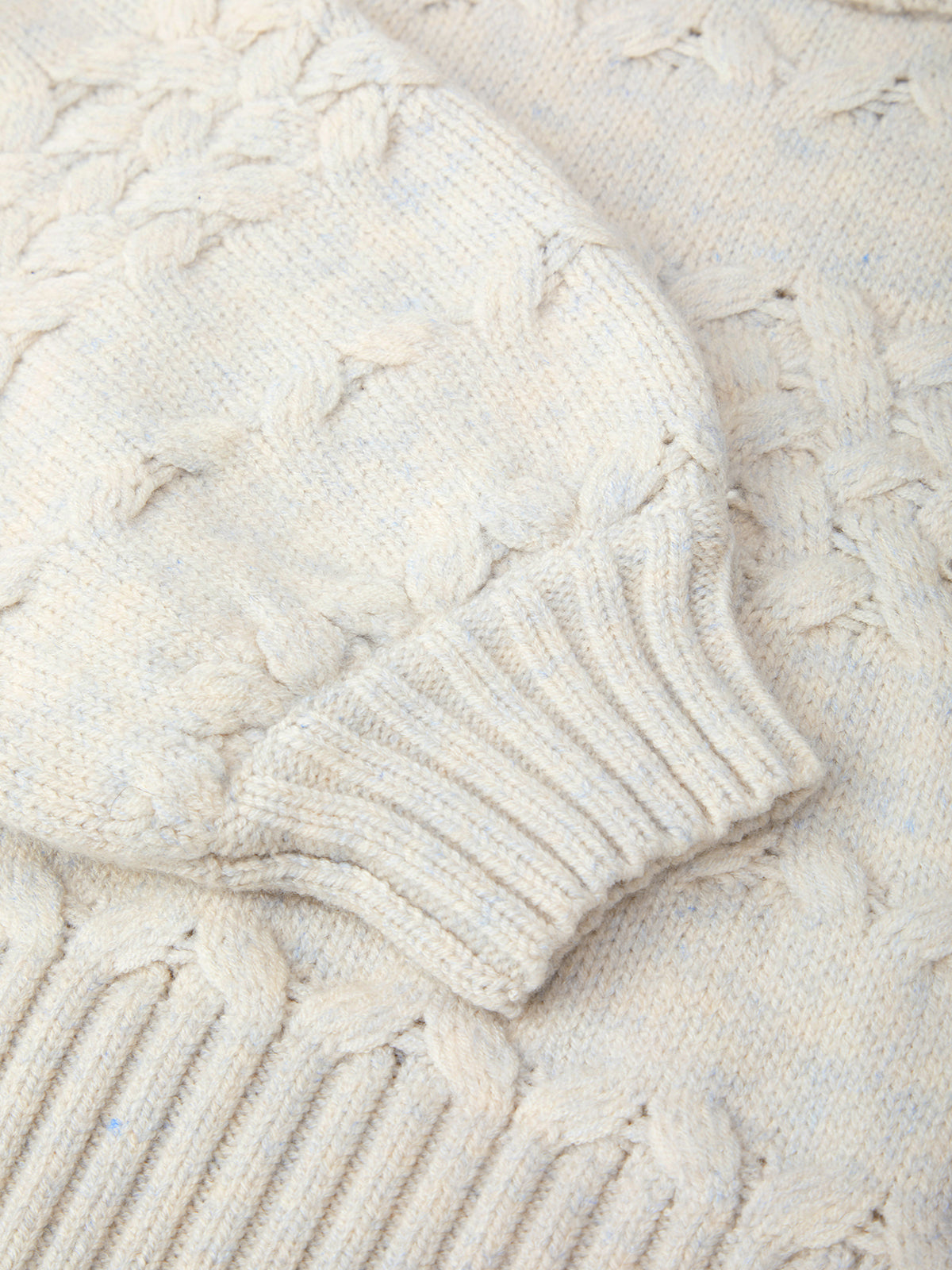 Close-up of a textured white fabric with cable knit pattern