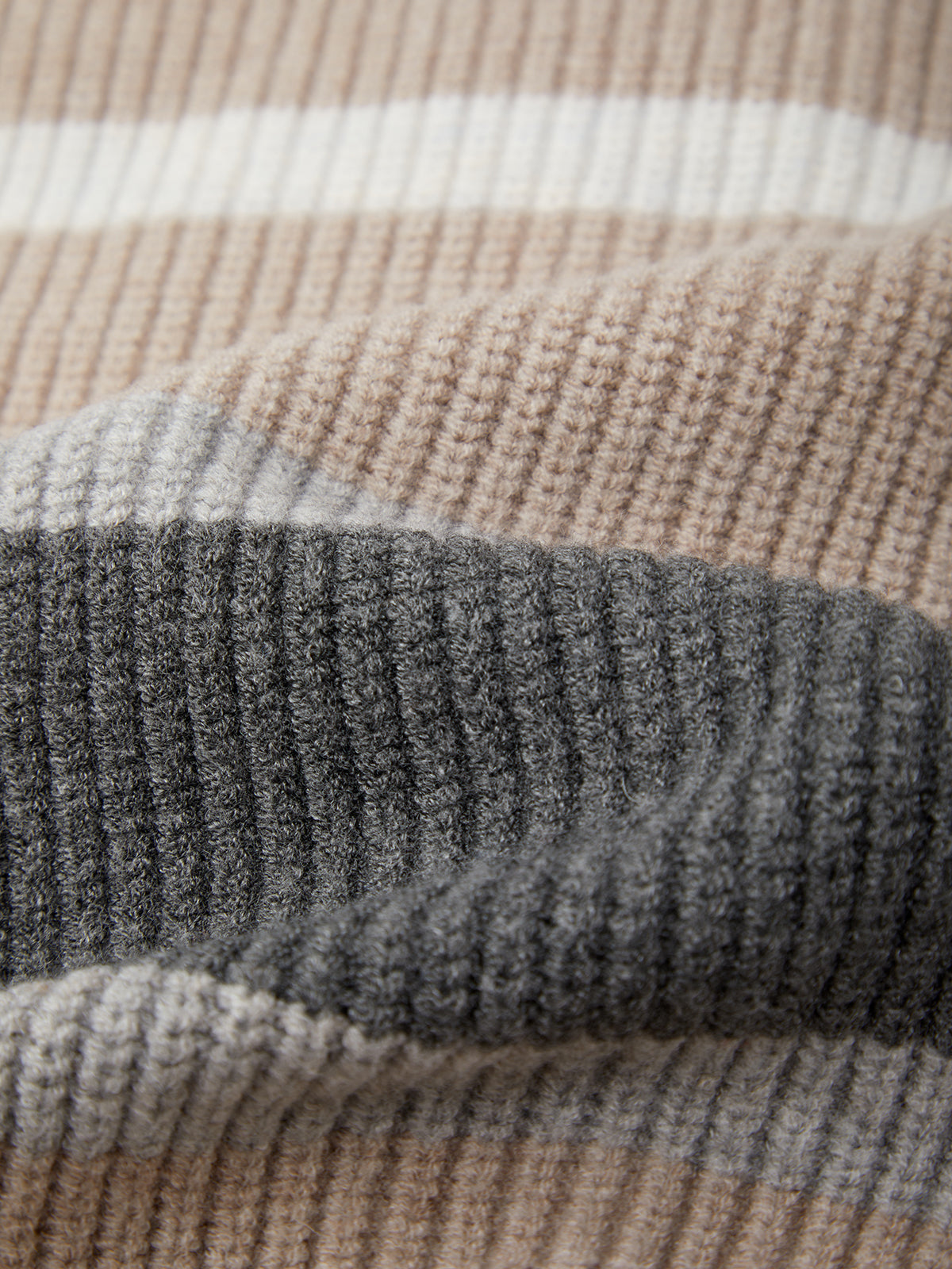 Close-up of textured fabric with horizontal stripes in brown, gray, and beige.
