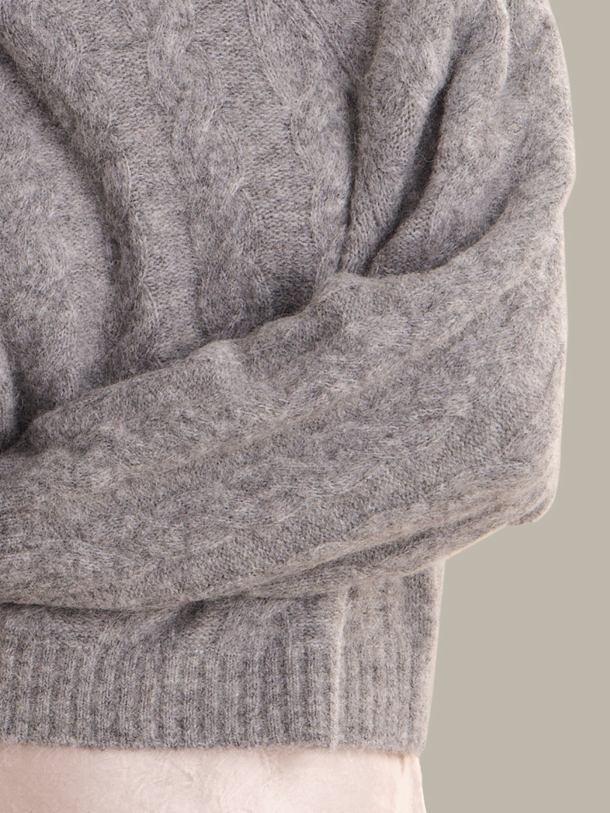 Close-up of a gray sweater with a neutral background