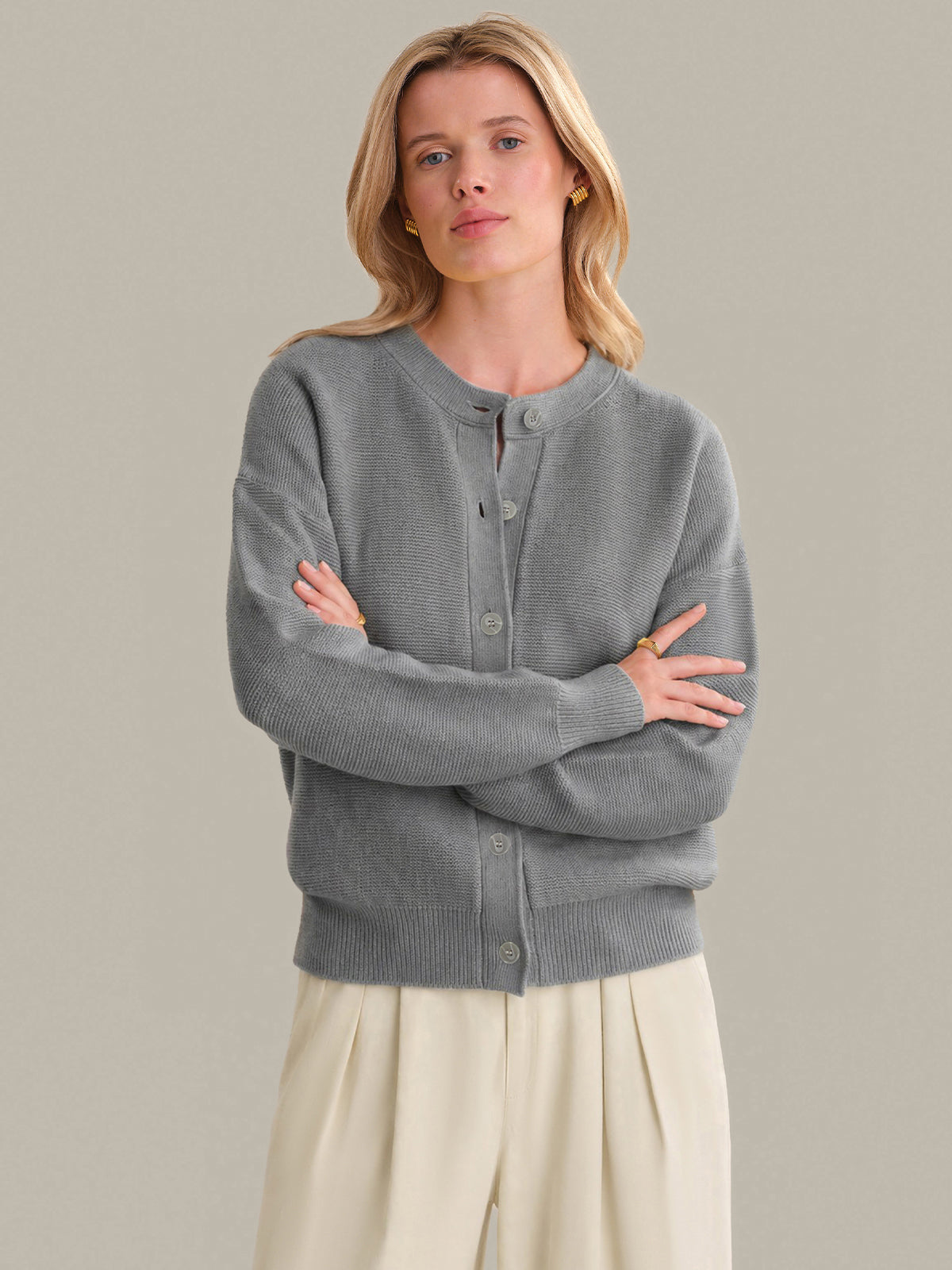 Woman wearing a gray cardigan with a neutral background