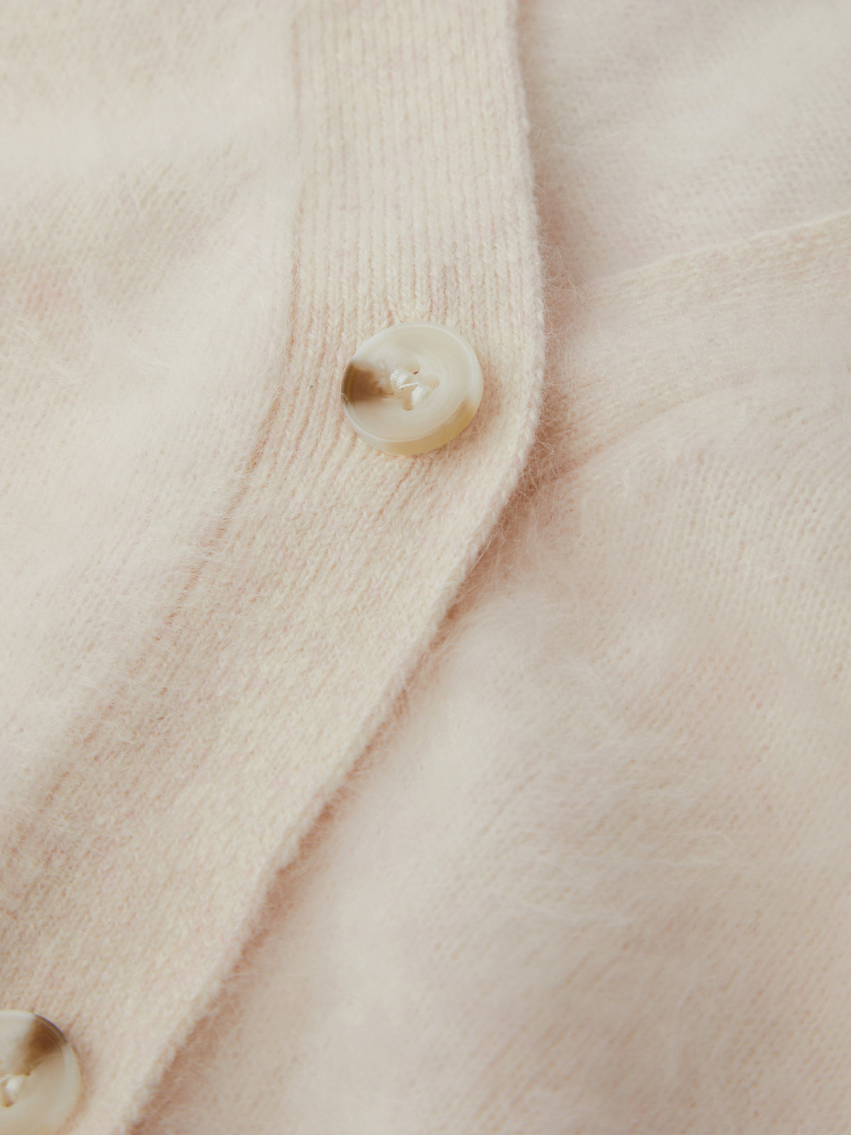 Close-up of a beige textured fabric with buttons