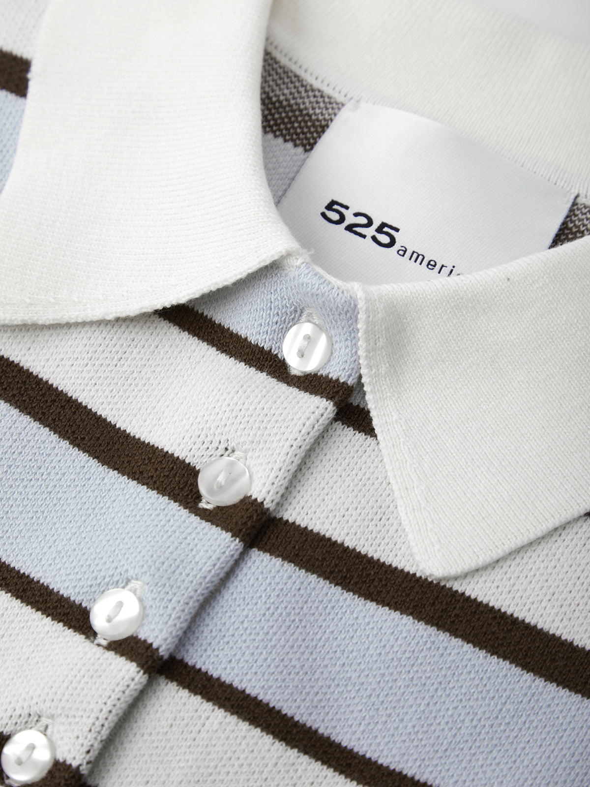 Close-up of a striped shirt with a brand label on a white background