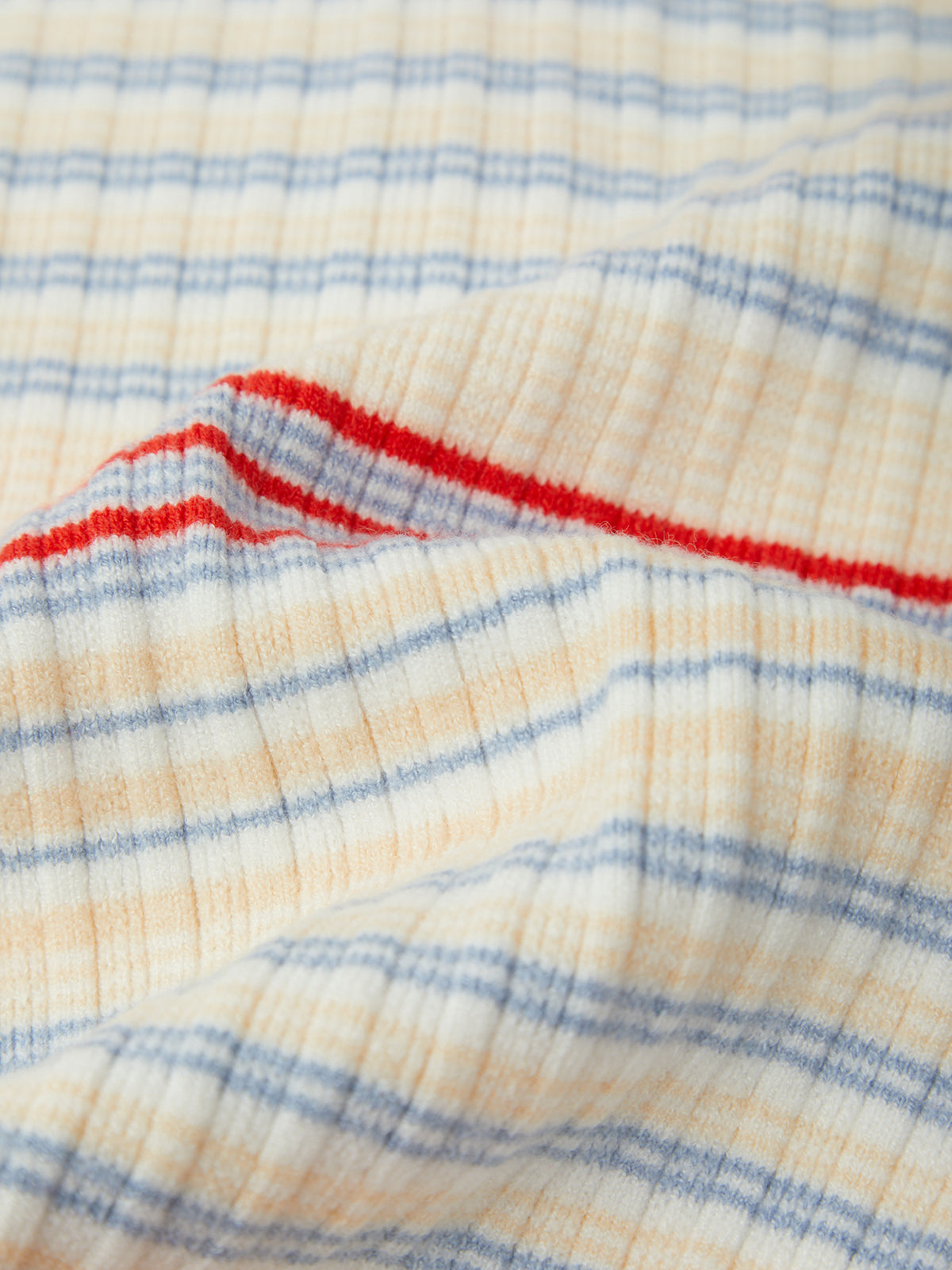 Close-up of checkered fabric with red, blue, and beige colors.