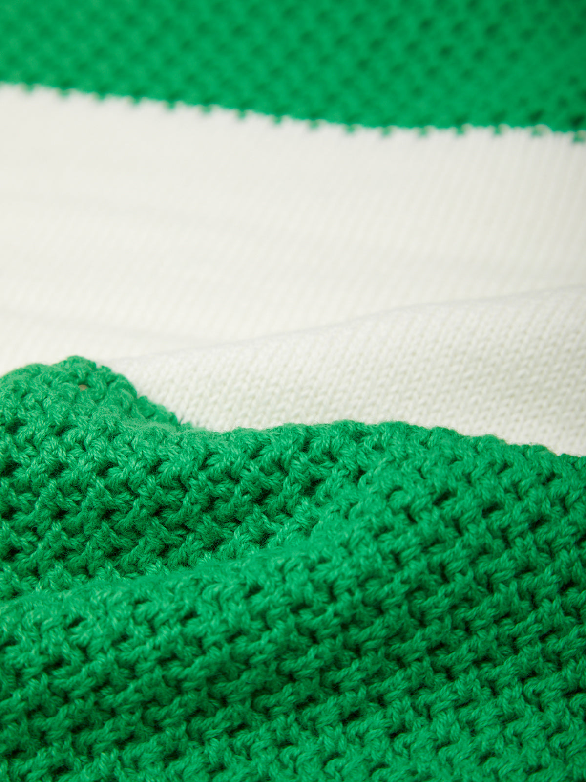 Close-up of green and white striped fabric with a textured pattern.
