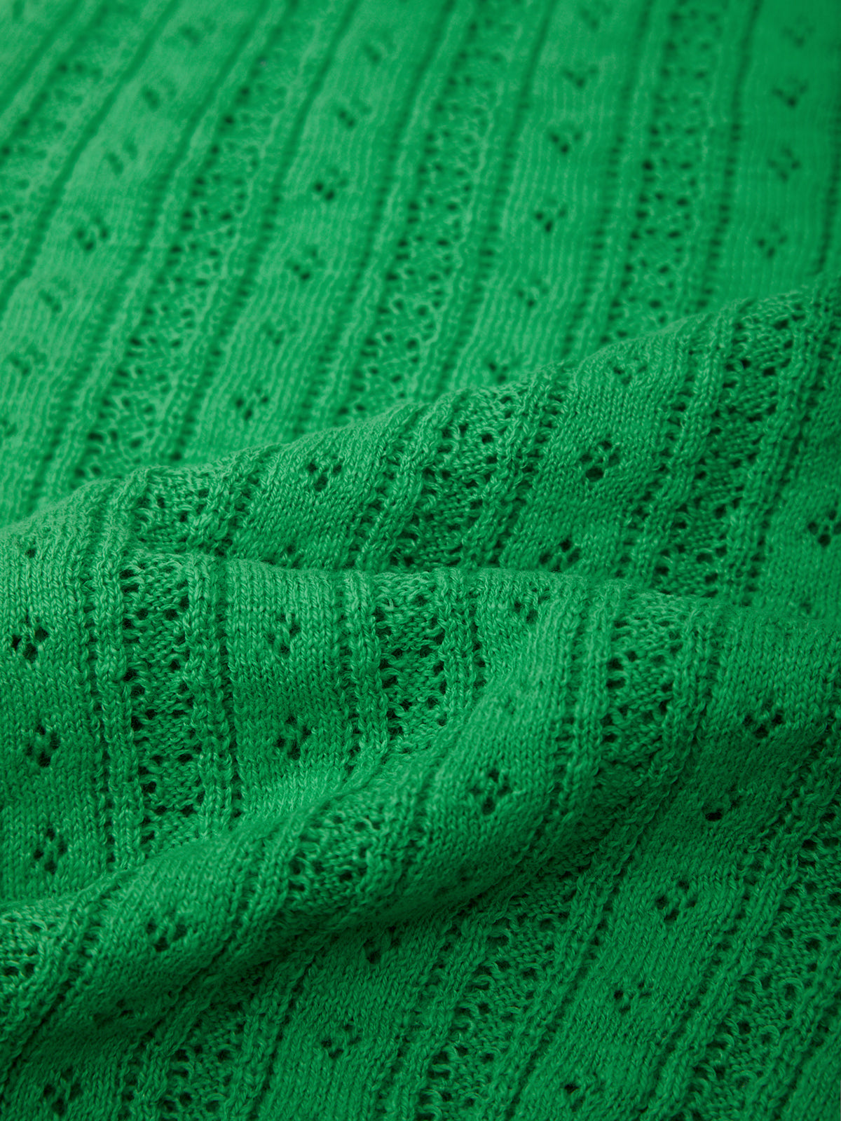 Close-up of green knitted fabric with a subtle pattern