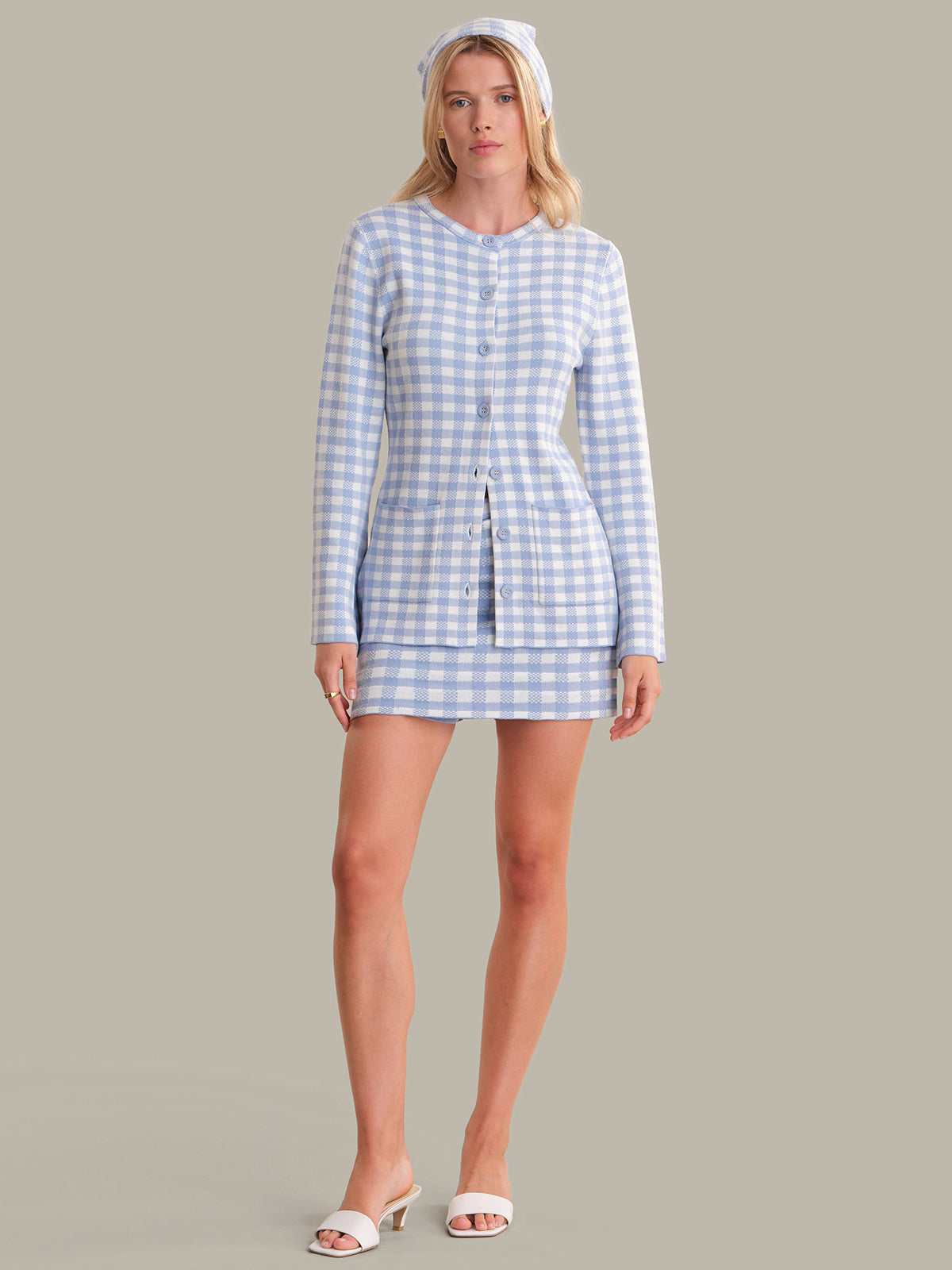 Woman wearing a blue and white checkered dress on a gray background
