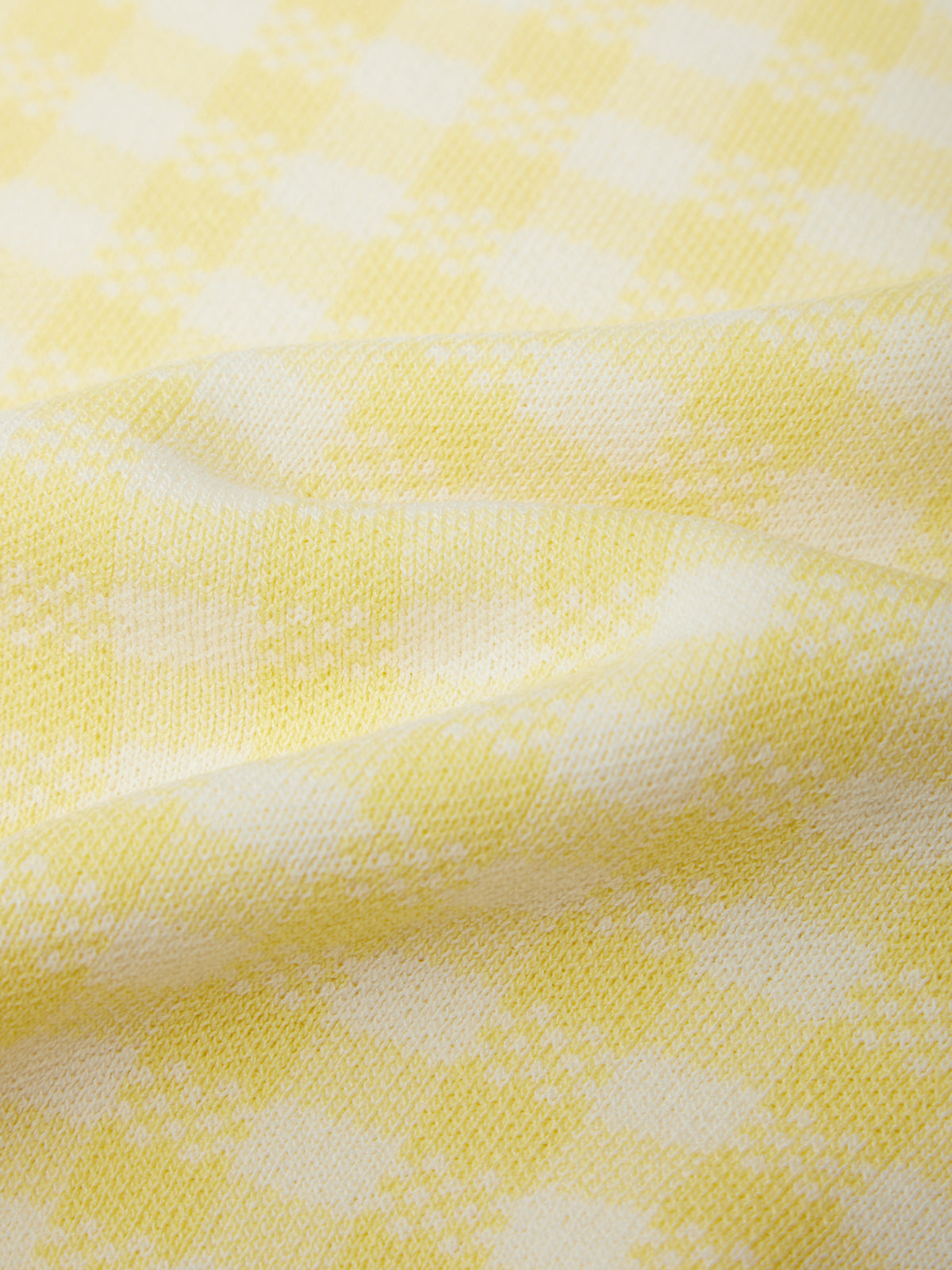 Close-up of yellow fabric with a subtle pattern