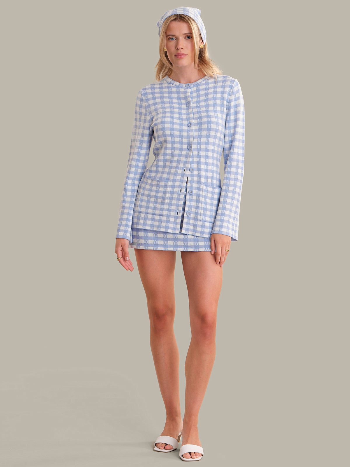 Woman wearing a blue and white checkered outfit on a gray background