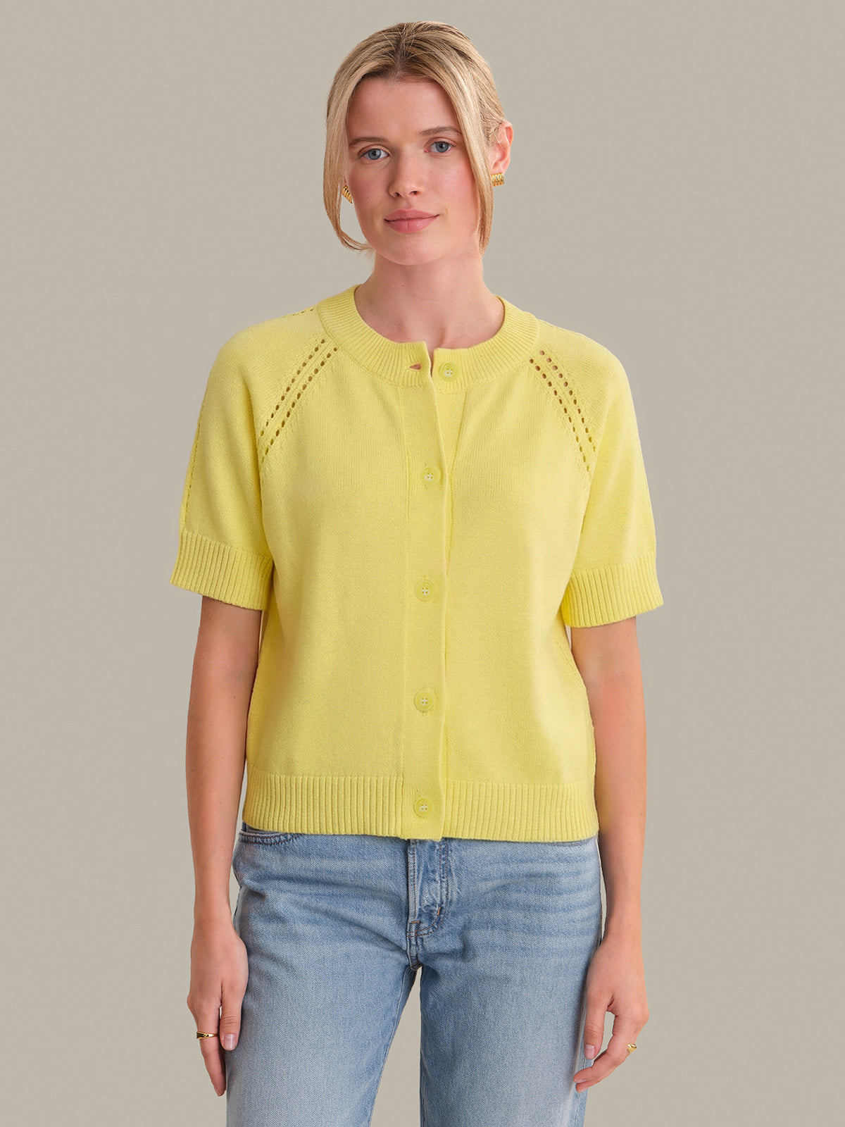 Woman wearing a yellow short-sleeve top with a neutral background