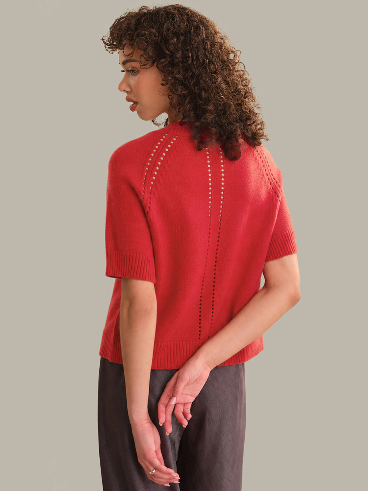 Woman wearing a red sweater with a neutral background