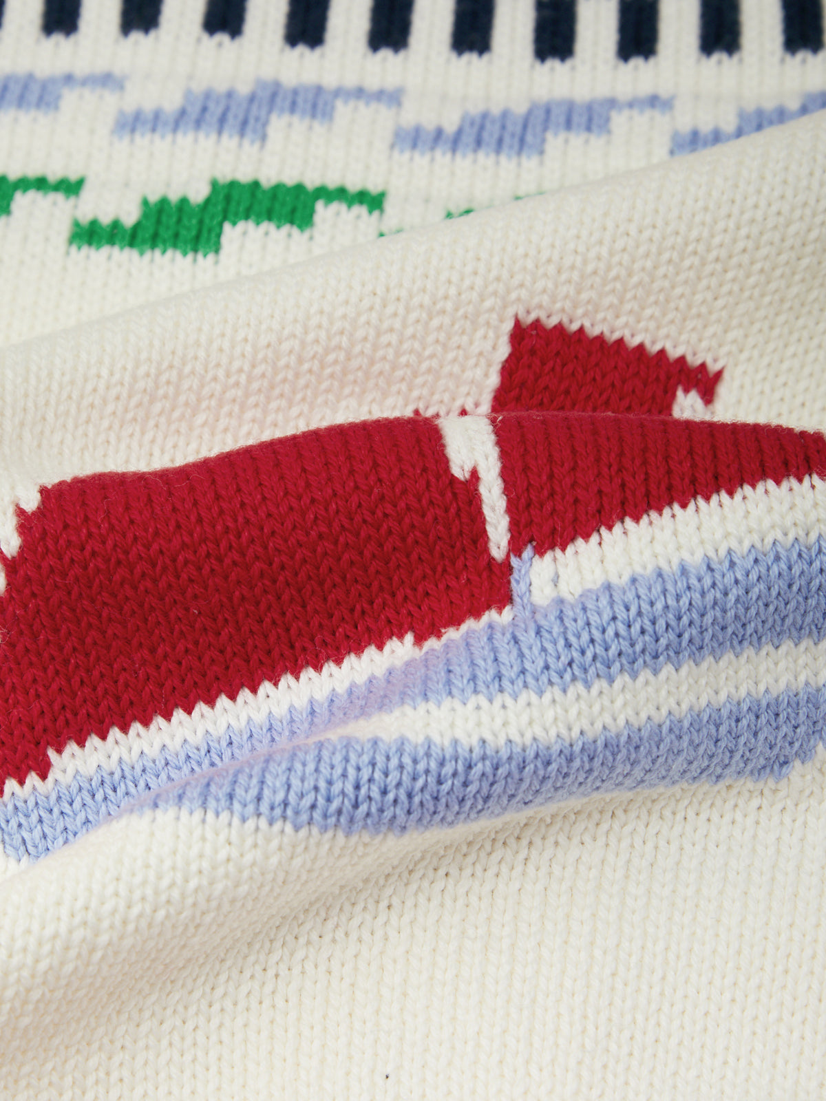Close-up of a knitted fabric with colorful patterns on a white background