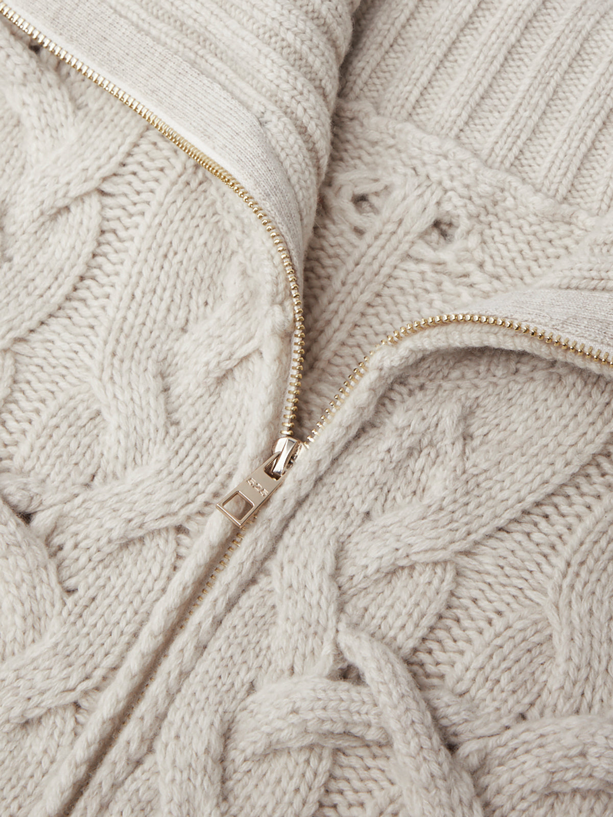 Close-up of a beige knitted sweater with a zipper