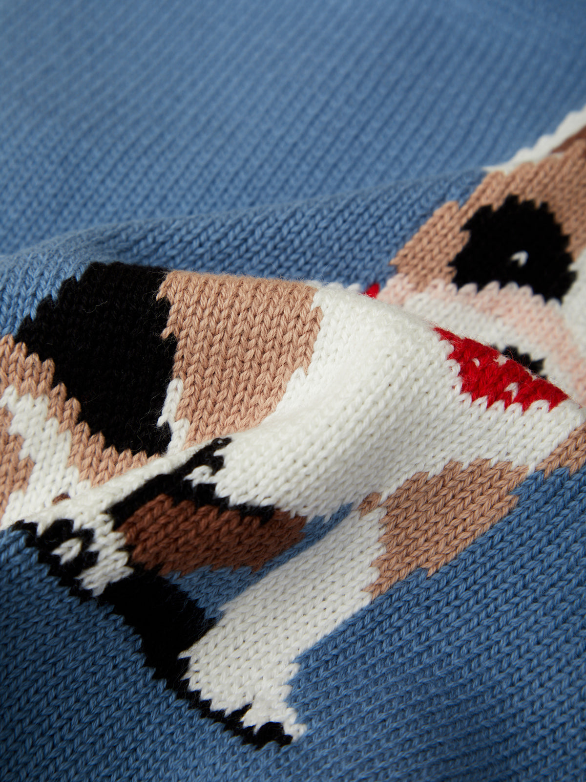 Knitted dog pattern on a blue fabric background