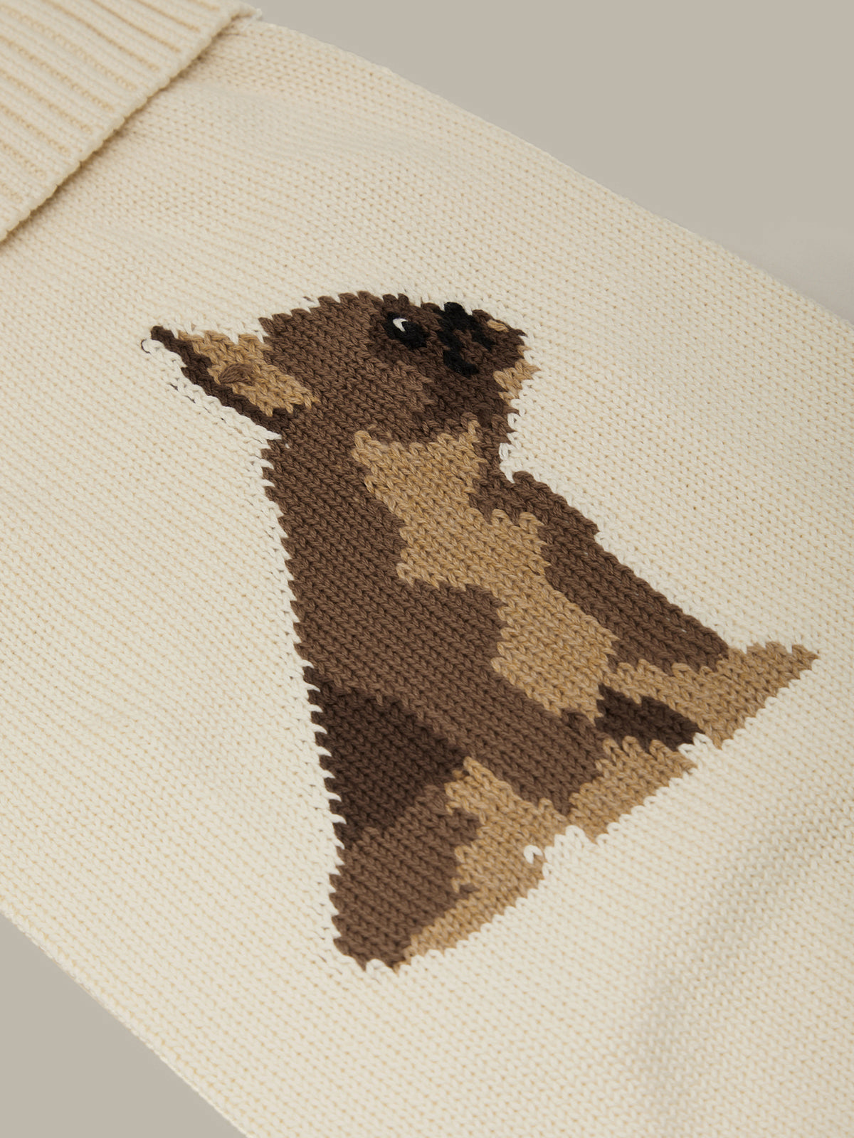Knitted pattern of a bird on a beige fabric background