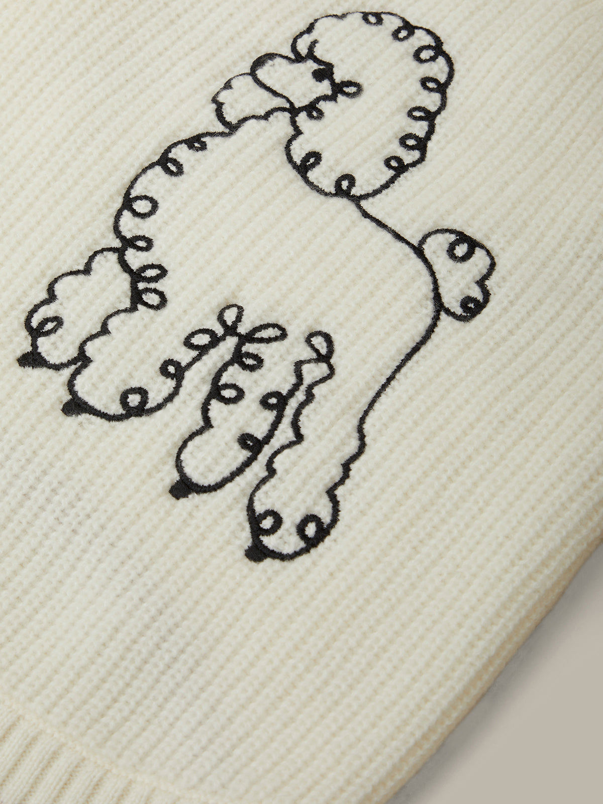 Embroidered poodle design on a textured fabric background