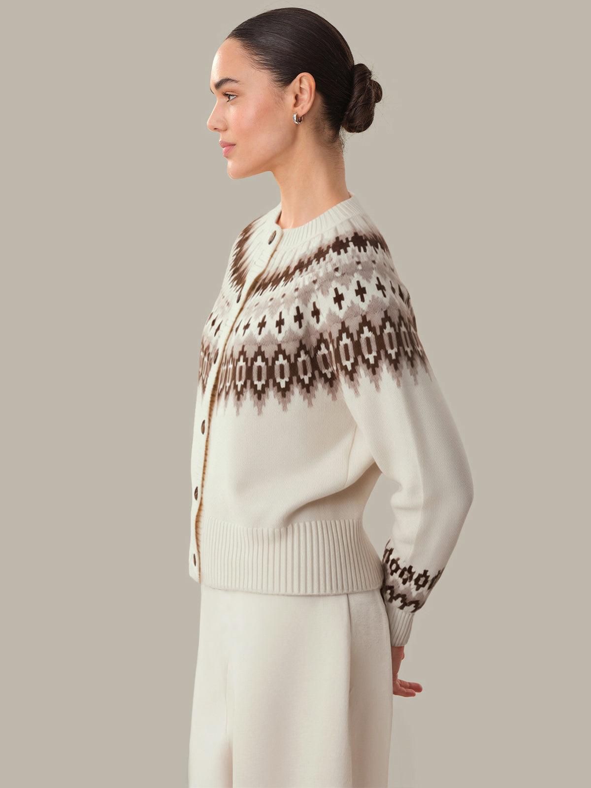Woman wearing a patterned sweater against a neutral background