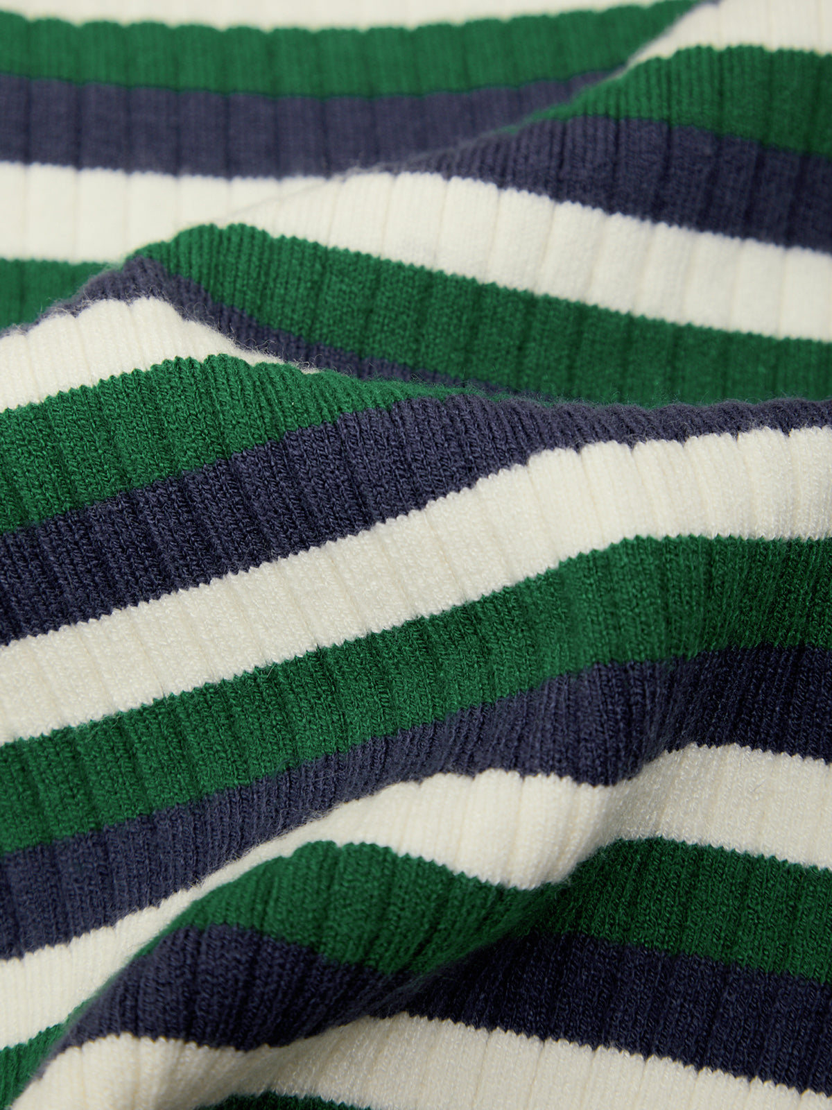 Close-up of a ribbed knit fabric with horizontal stripes in green, navy blue, and white.