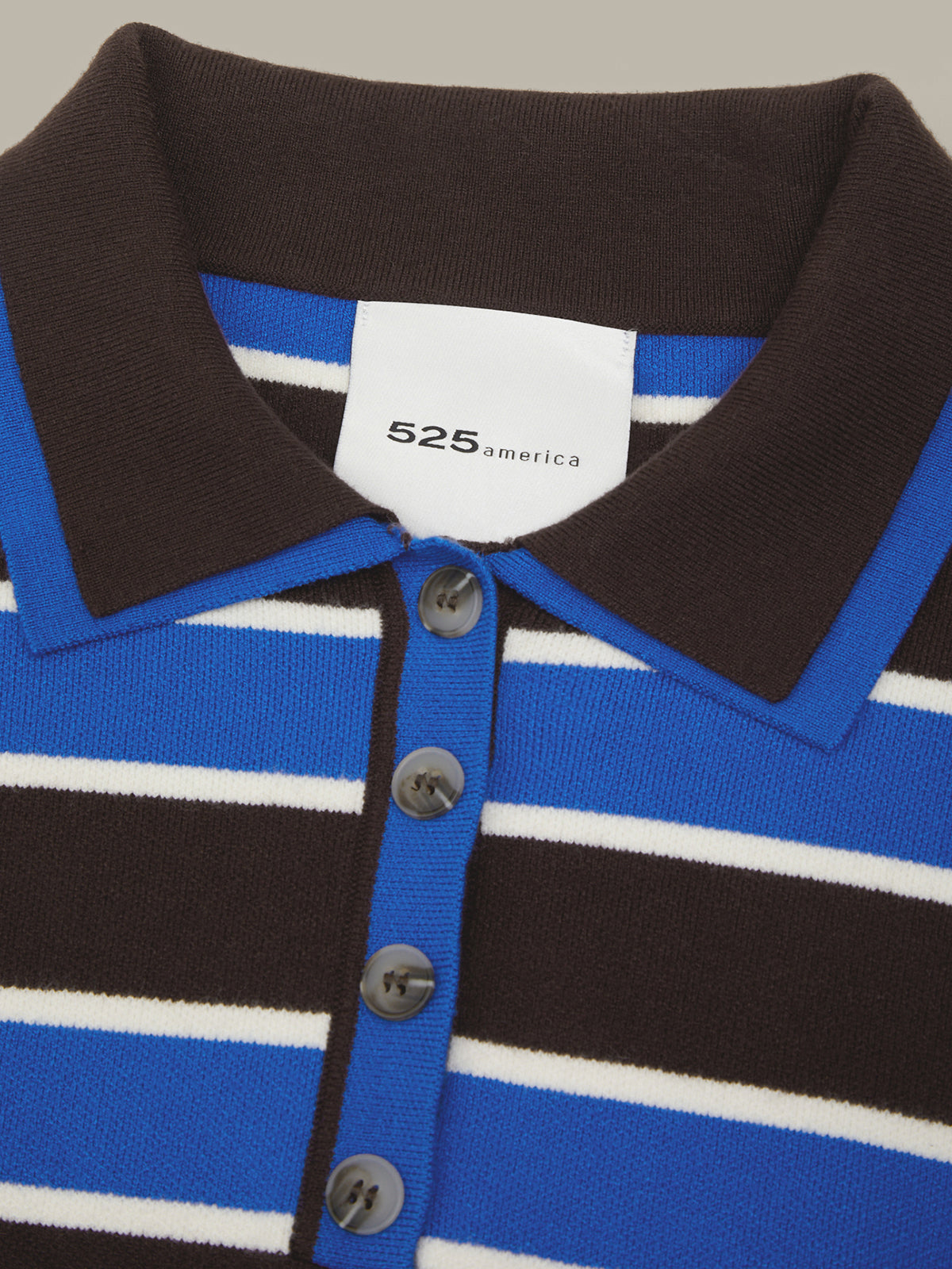 Close-up of a striped knit polo shirt collar and button placket. The shirt has a dark brown collar and upper chest, bright blue midsection, and horizontal white stripes across both.