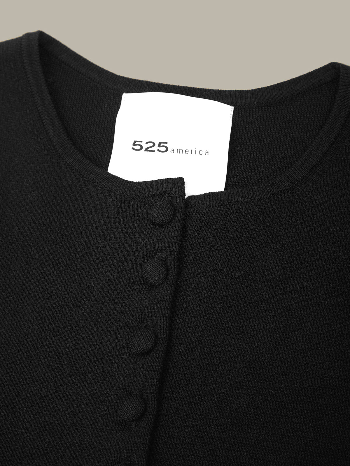 Black shirt with a visible brand label on a neutral background