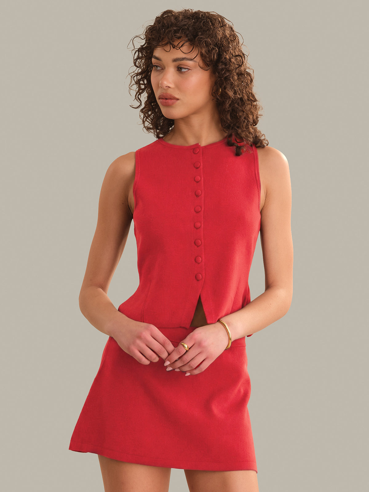 Woman wearing a red sleeveless dress against a plain background
