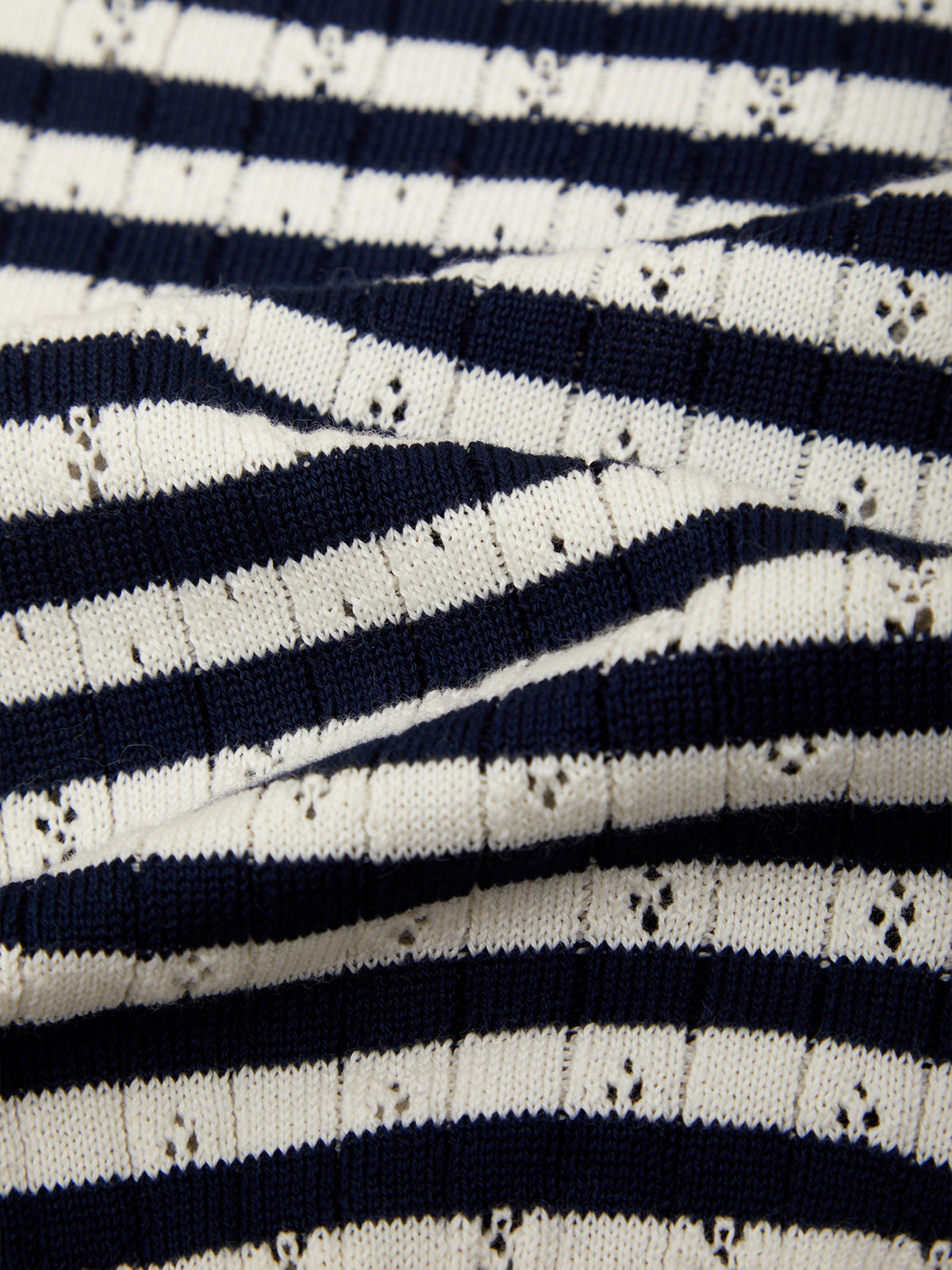 Close-up of a navy blue and off-white striped knit fabric with a textured, ribbed pattern.
