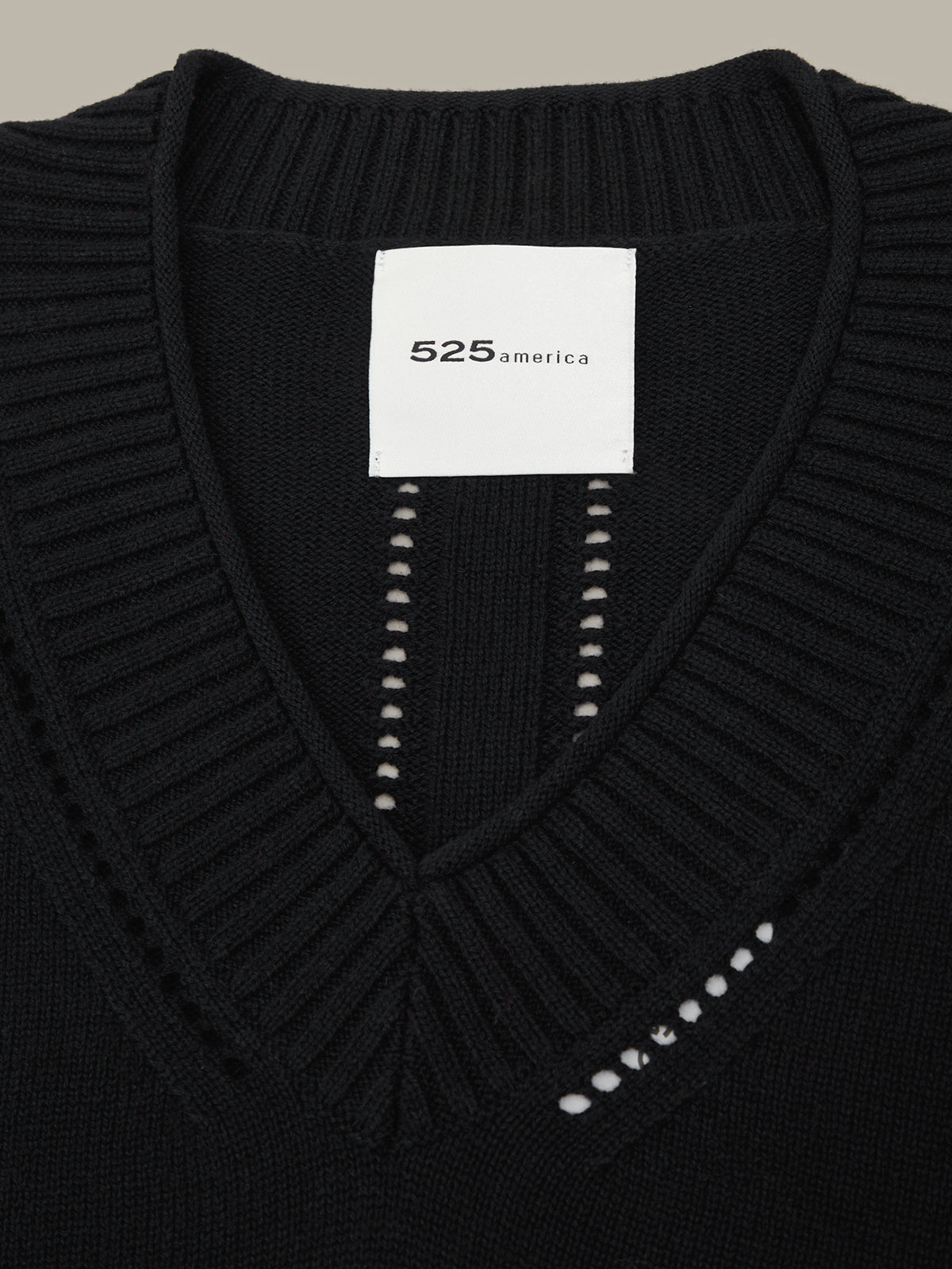 Black sweater with a brand label on a black background
