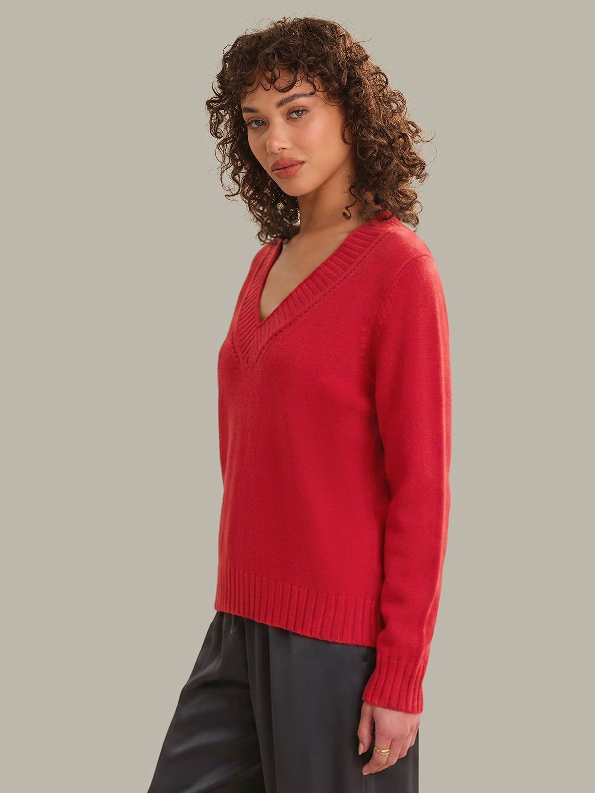 Woman wearing a red sweater against a neutral background