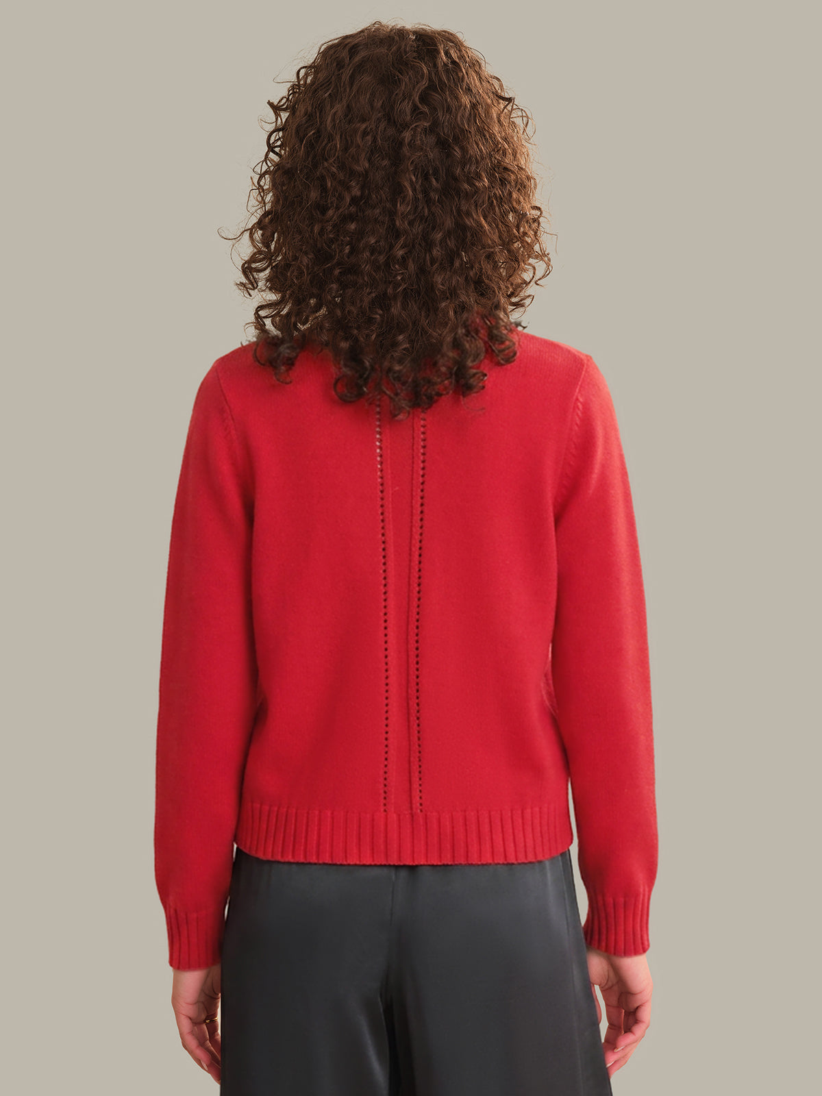 Person wearing a red sweater with a plain background