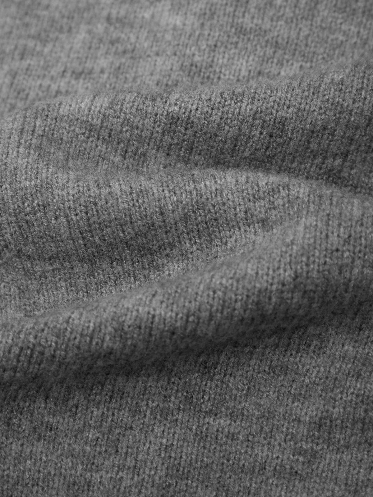 Close-up of a heather gray knit fabric texture with soft folds and ribbed weave.