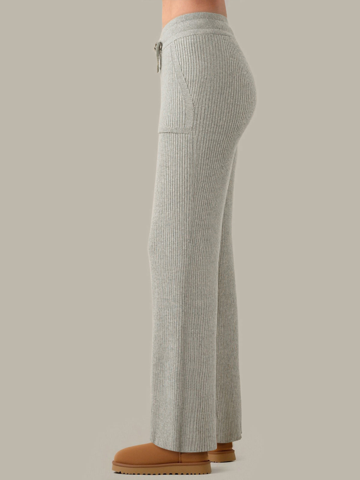 Gray ribbed pants worn by a person on a neutral background