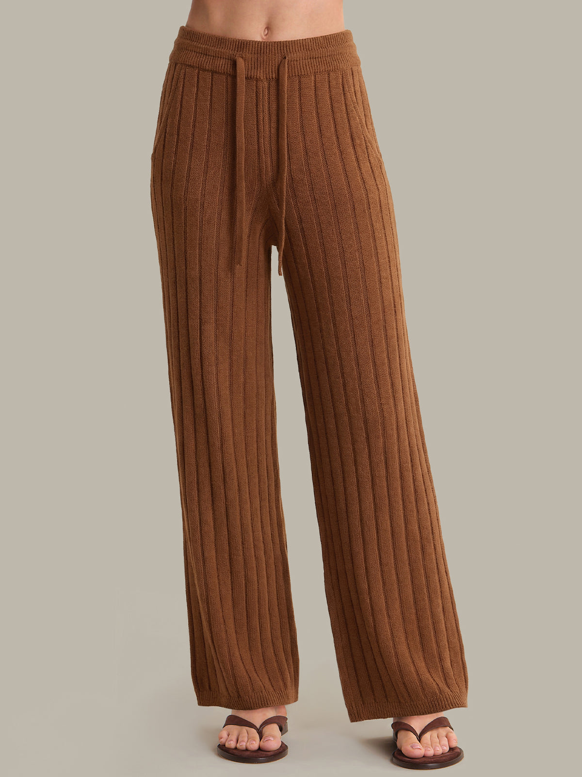 Brown ribbed pants on a neutral background