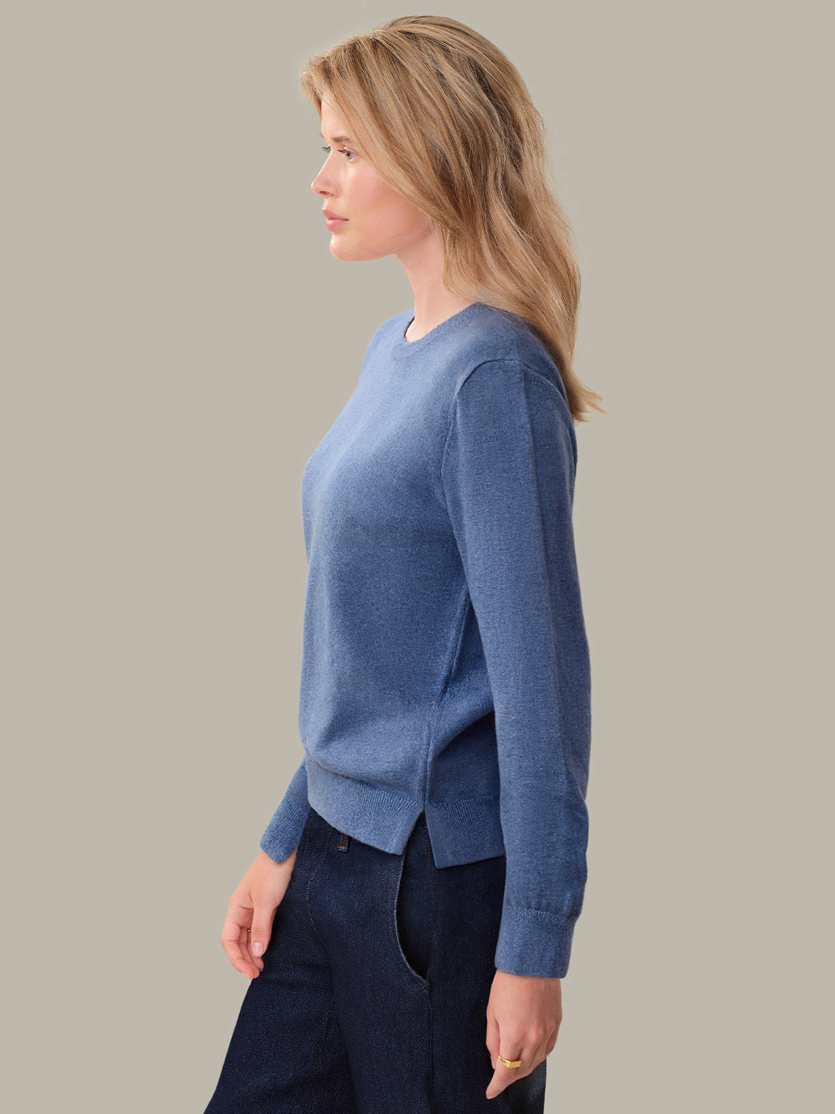 Woman wearing a blue sweater against a plain background