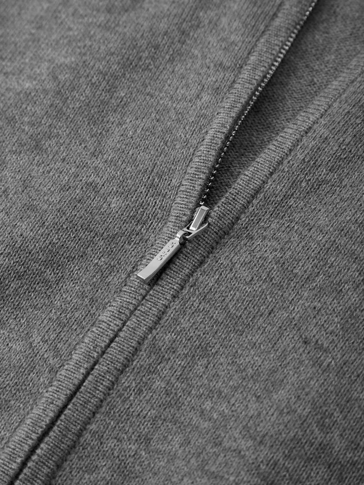 Close-up of a zipper on a gray fabric surface