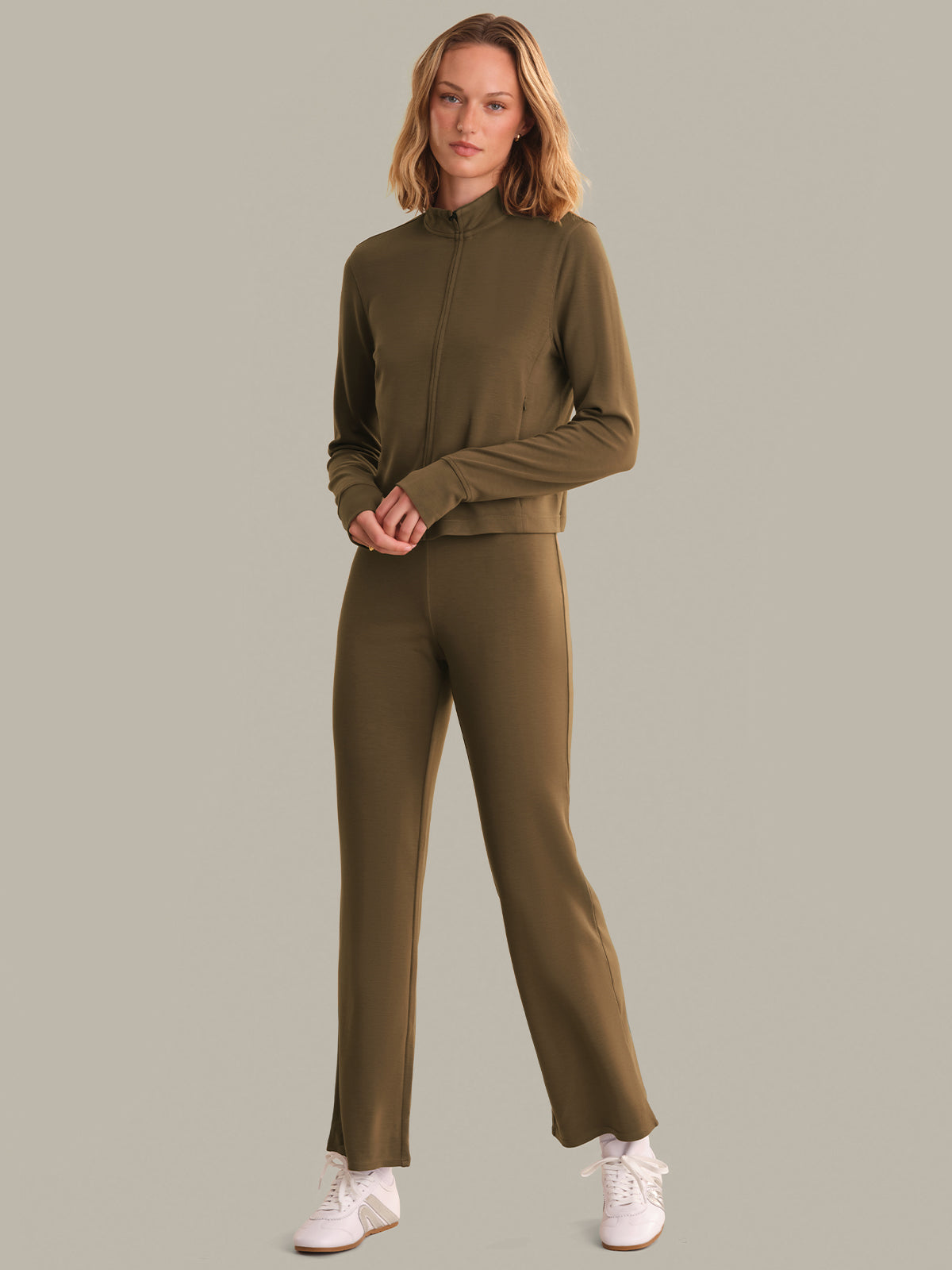 Woman wearing an brown tracksuit on a gray background