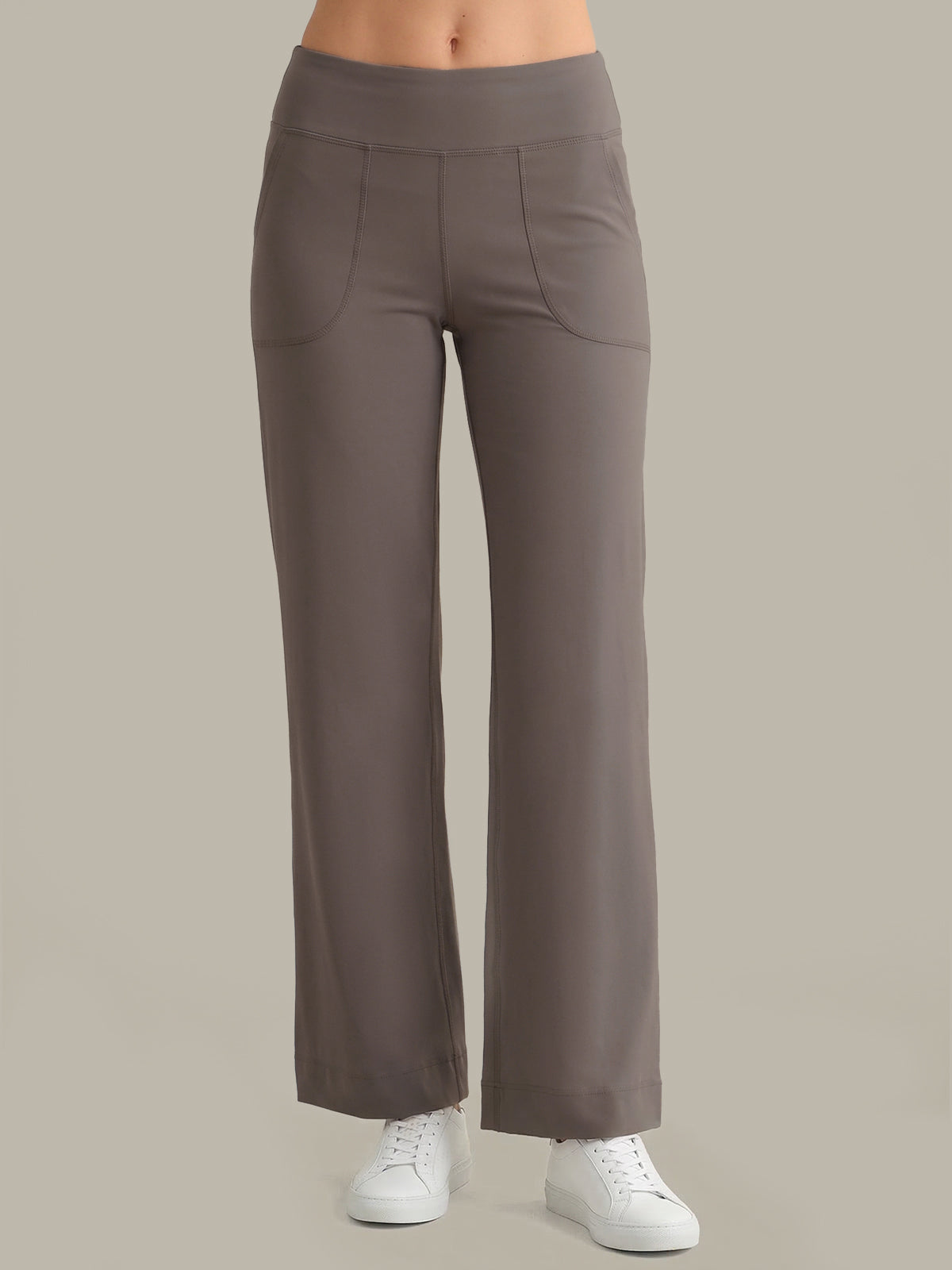 Grey pants worn by a person on a beige background